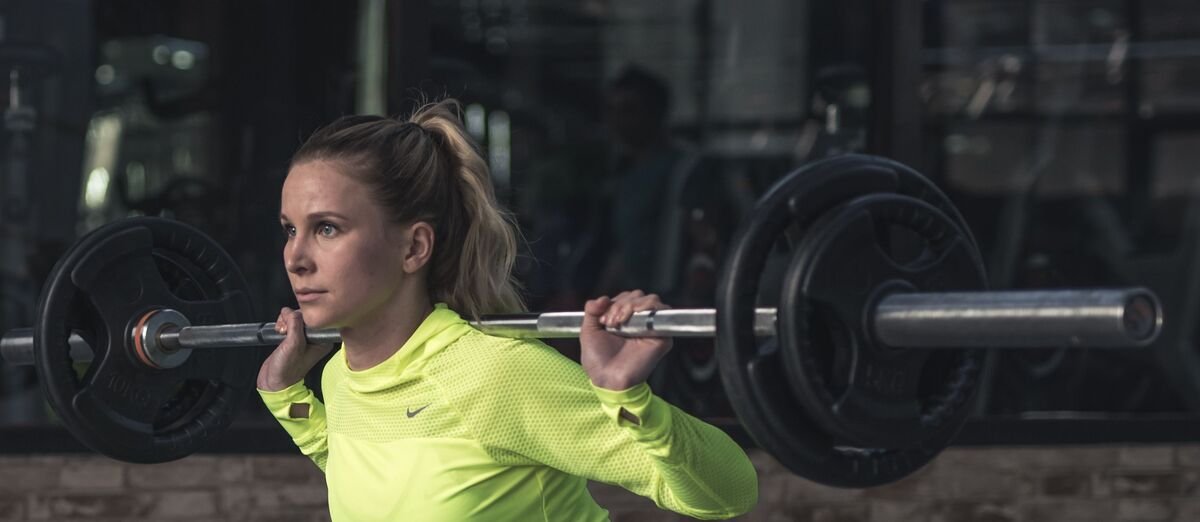 Woman lifting a barbell in a gym